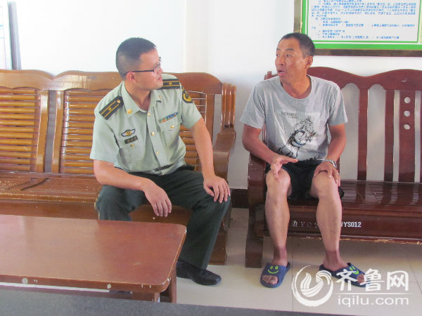 长岛县砣矶边防派出所民警与获救男子交谈。