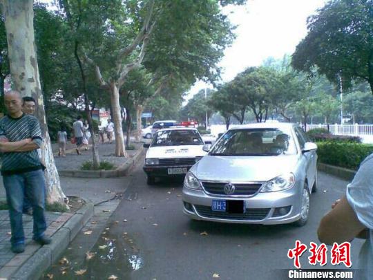 图为违停车辆将警车逼停后，司机锁门离开。 吴奇勇 摄