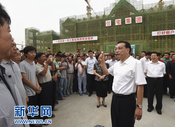这是李克强来到天津市西于庄棚户区迁建施工现场看望正在看房的拆迁安置群众。 新华社记者李学仁摄