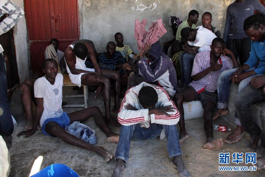 　　 9月15日，在利比亚加拉布里，获救的非法移民坐在一栋房子内。当日，利比亚海军发言人阿尤布·卡西姆证实，一艘载有约200名非法移民的船只14日在利比亚首都的黎波里附近海域沉没。利比亚海军方面目前已经救起36人。新华社发（哈姆扎·图尔基亚摄）