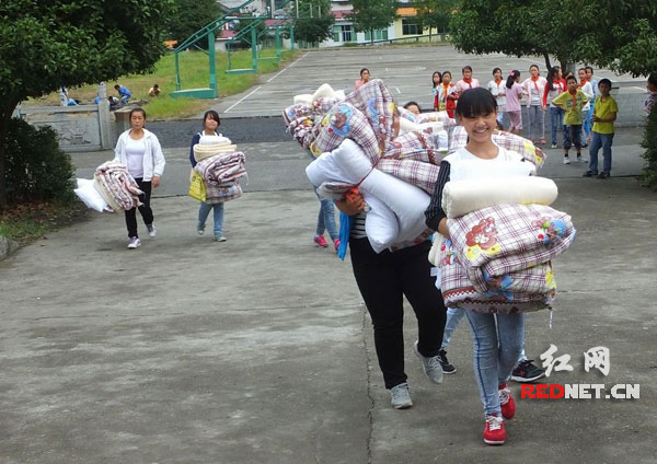 9月22日，湖南省保靖县清水坪学校的学生正在开心地搬运新棉被。