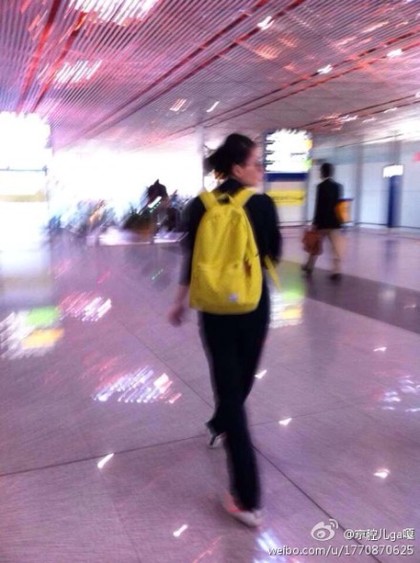 王菲青春装扮现身北京机场 手机不离手