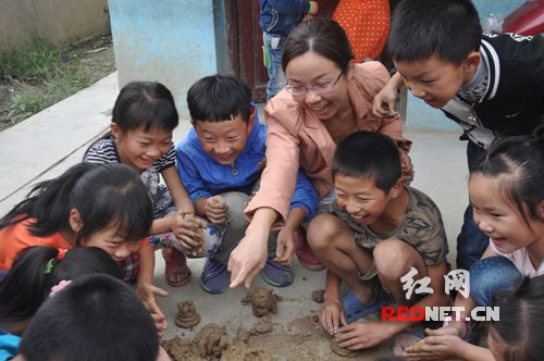 9月29日，湖南省隆回县金石桥镇高洲完小泥塑辅导教师杨牡花正在开心地和孩子们分享捏“泥猪”带来的快乐。