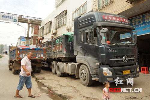 两辆大货车把人行道和机动车道当成停车场，非法占道停车、装卸货物。