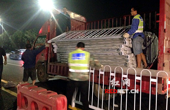 工作人员正从卡车上将护栏卸载下来。