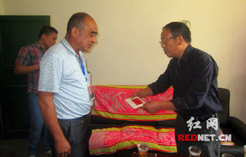 湘潭市红十字会副会长李透把慰问金送到送至湘乡市虞唐镇敬老院院长手中。