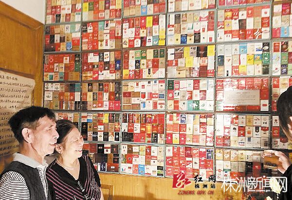 老胡(左一）给前来参观的居民介绍烟盒。张红霞 供图