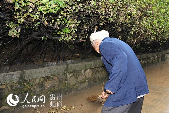 刘福昌老人正在清扫红军烈士陵园内的枯枝散叶。王钦摄