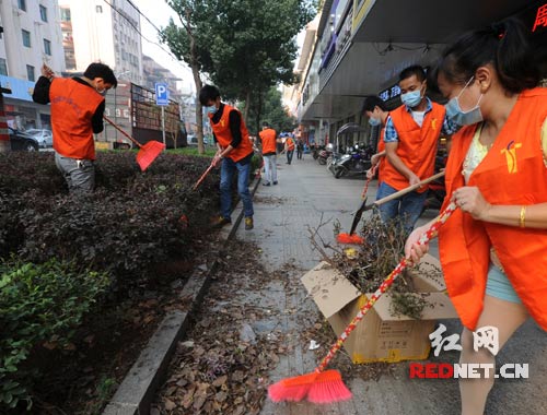 双峰县城复兴路农贸市场路段，义工在清扫垃圾