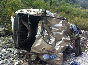 面包车摔在河边乱石上。