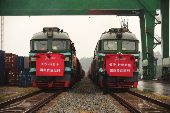 10月30日,长沙霞凝货场,两列满载湖南特色产品的湘欧国际货运班列即将启程,机组人员在出发前拍照留念。图 记者谢长贵