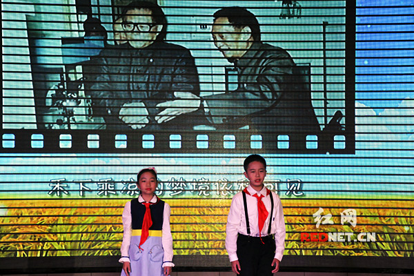 学生为庆祝超级杂交水稻亩产过1000公斤献诗。