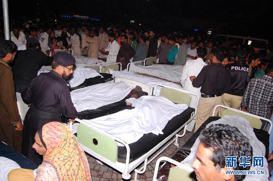 11月2日，在巴基斯坦拉合尔的一家医院，家属站在遇难者遗体旁边。