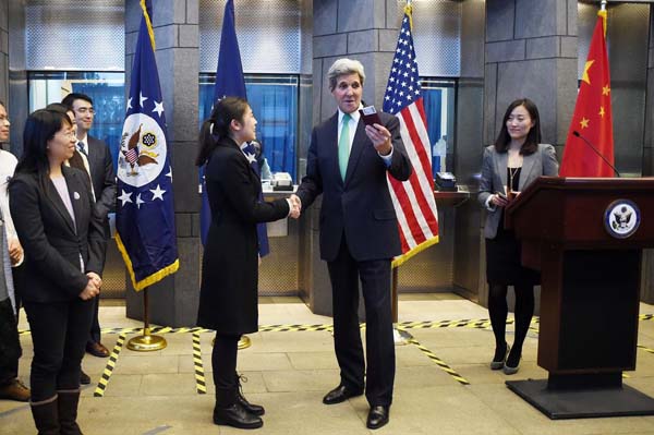 美国国务卿克里为首批获得最长10年美国签证的中国申请人颁发新签证。