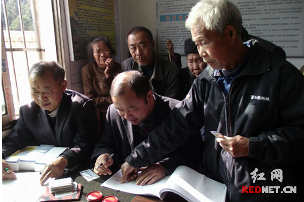 78岁彭上云老人正在按手印领卡