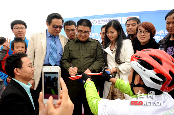 担任“环湘赛形象大使”的著名企业家陈光标正在为选手签名留念。