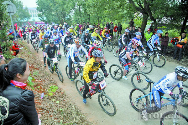 选手们努力向山顶骑行。 记者 罗韬 摄