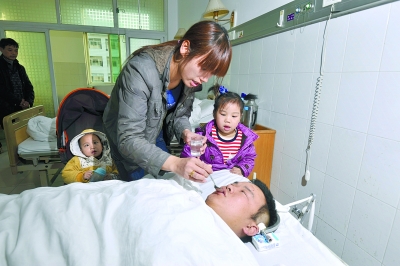11月19日下午，湖南省马王堆医院，陆荣华带着两个孩子在医院给丈夫蒋科平喂水。