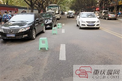 用小板凳旧摩托占停车位 一经发现立即暂扣