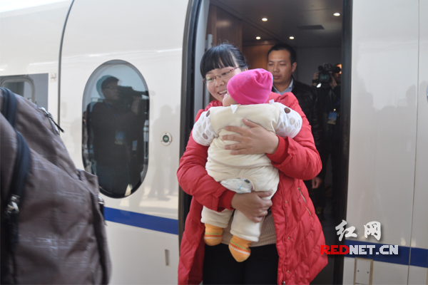 上车1小时后，高铁列车就到了邵阳北站，王女士抱着孩子高兴地走出车厢。