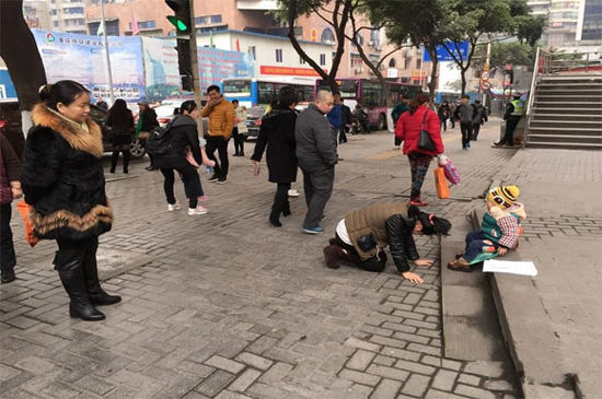 无助妈妈当街向2岁重病儿子下跪。图据网络