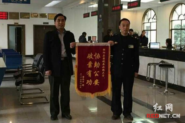 纳税人赵长日（左）将锦旗送到衡阳县国税局办税大厅。