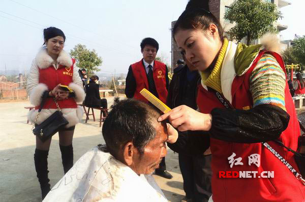 义工在帮邵阳县下花桥镇敬老院孤老理发。