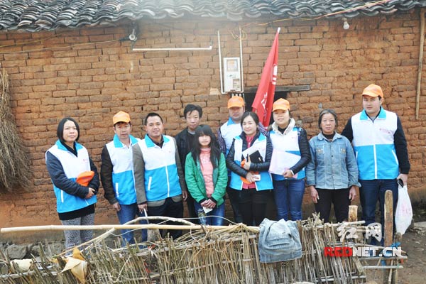 义工与水美塘村贫困学生王香香一家合影。