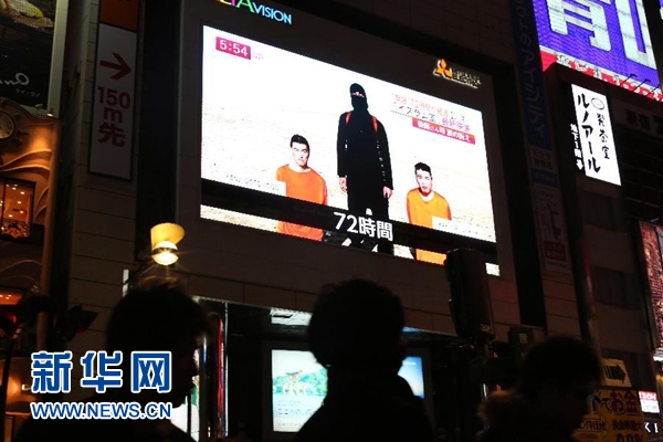 1月23日，在日本东京，一块显示屏播放有关遭绑架的日本人质的新闻。新华社/美联