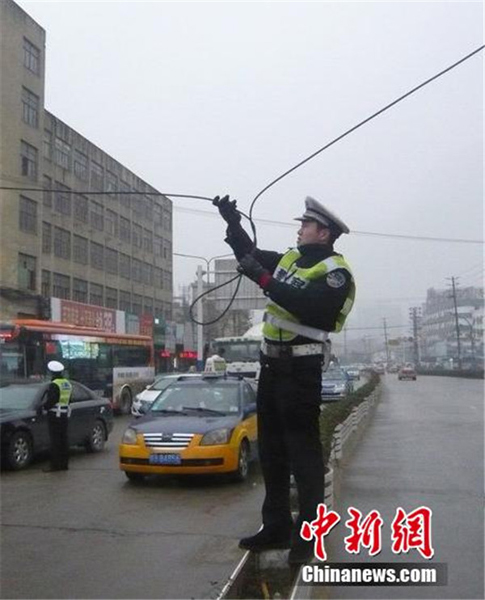安徽芜湖:交警雨中托举电缆2个多小时让车通行