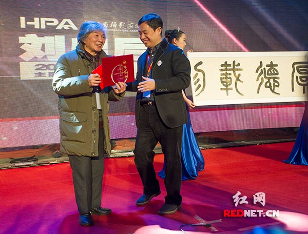 全国人大代表、湖南省摄影家协会主席谢子龙（左二）为湖南本土民俗摄影家老后（左一）颁发省影协2014年度最高奖“主席特别提名奖”。