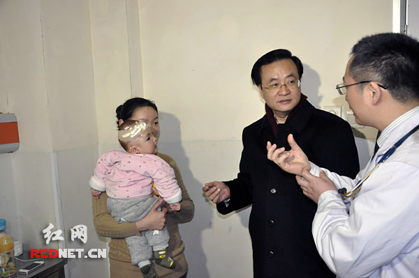 2月11日，湖南省副省长李友志（中）听取省儿童医院医生对患儿情况的介绍。