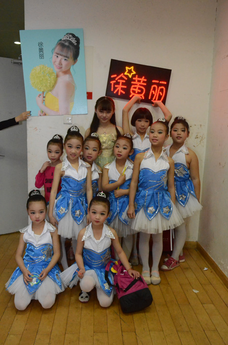 图为徐黄丽与快乐天使艺术中心孩子们在晚会后台合影