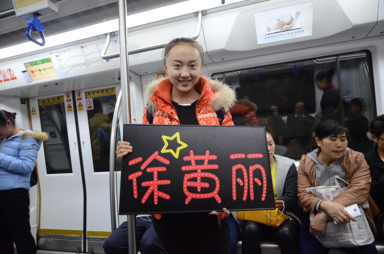 图为徐黄丽好友杨煜杰小歌手在地铁上宣传徐黄丽