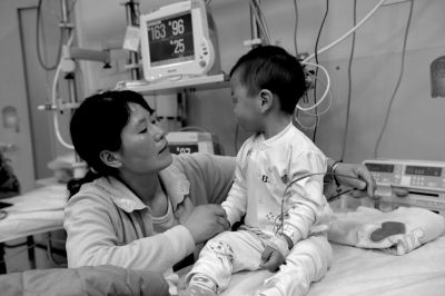 孩子在儿童医院急诊留观室输液治疗，他妈妈在一旁照看。京华时报记者赵思衡摄