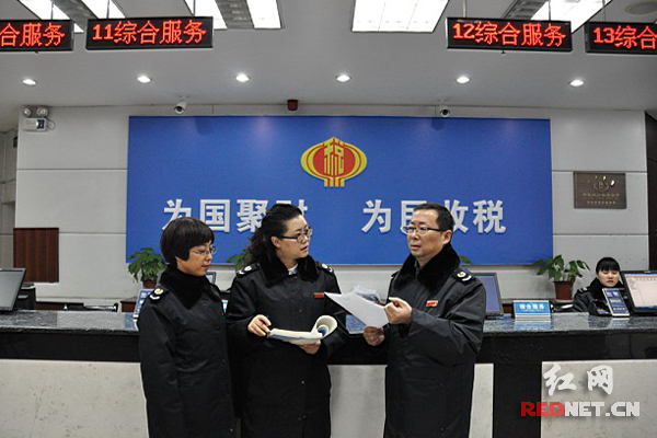 怀化市鹤城区国税局局长李杰（右一）到办税服务大厅值班。
