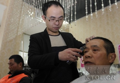 店长黄炯正在为一名环卫工理发。图/湘潭晚报记者 张哲