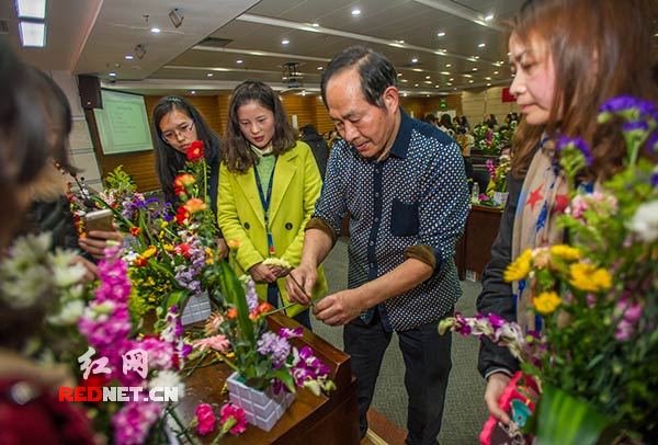 插花老师[右二]为参加花艺培训的女职工进行现场示范。