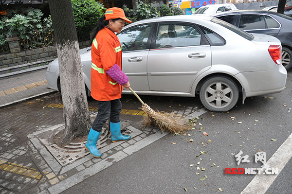 图为环卫工人刘汉娥清扫街道。