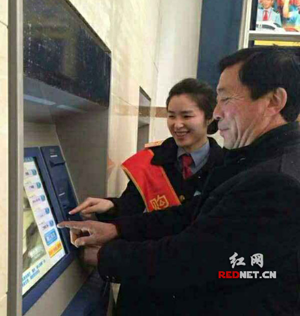 图为李悦在常德火车站引导旅客使用自动购票机。