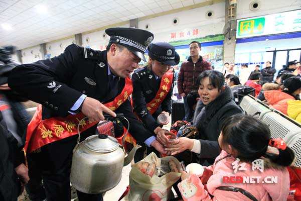 在候车室为旅客送上热茶水