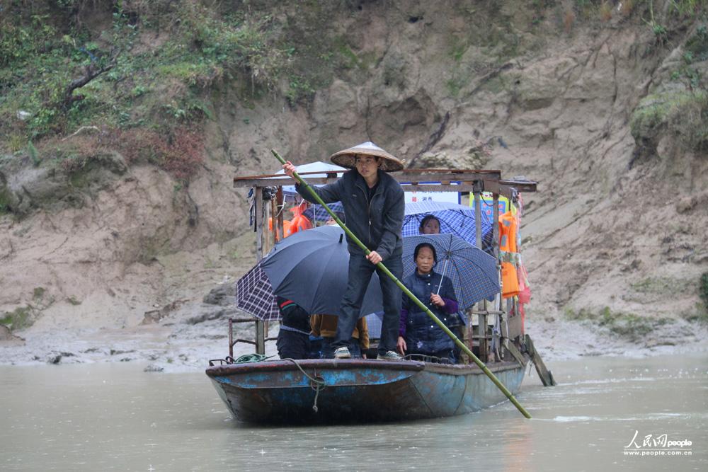 12月3日，任达兵撑船送孩子们渡河去上学。（人民网记者 郝迎灿摄）