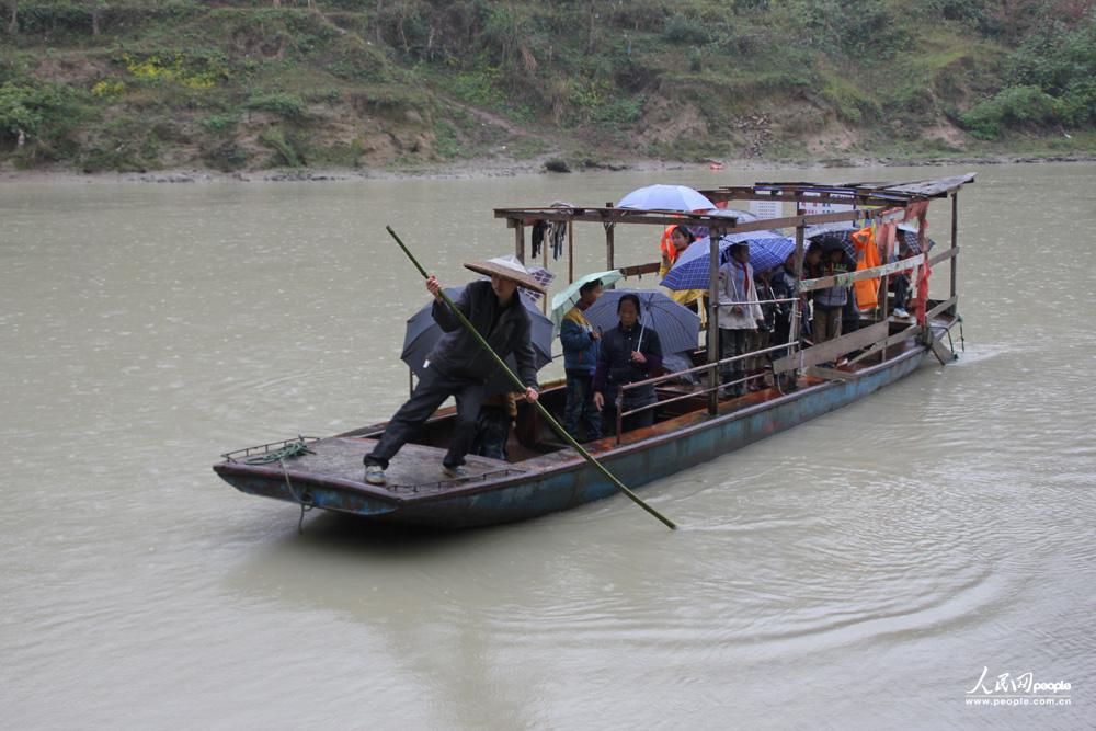 12月3日，任达兵撑船送孩子们渡河去上学。（人民网记者 郝迎灿摄）