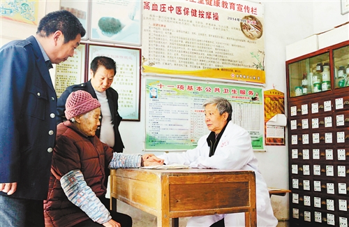 李国光在给村民看病。重庆晨网记者 张旭 摄