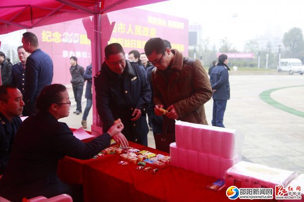 大祥区工商局工作人员正在给市民讲解如何辨别假冒伪劣产品。