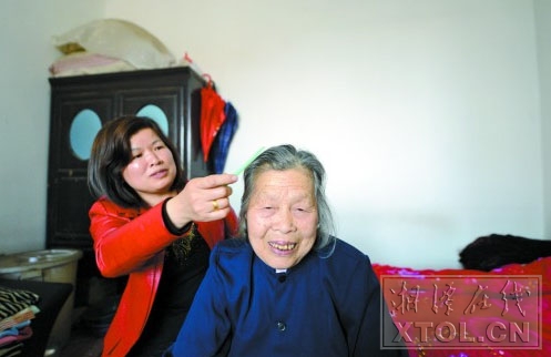 刘重香在给婆婆梳头 （记者 陈旭东 摄）