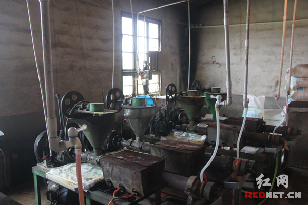 厂房内生产机器上结着铁锈和蜘蛛网，卫生条件很差。