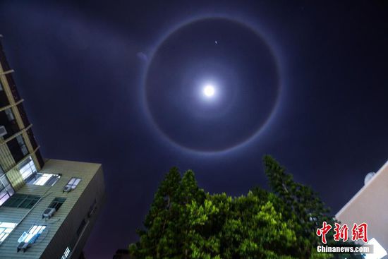 3月31日晚，福建平潭的夜空出现罕见的“月晕”景象。明亮的月亮周围，出现了一个巨大的圆环。而包围月亮的圆环出现了红黄紫等多种颜色，宛如一道圆形的彩虹。这个彩色圆环十分完整、清晰，直径也非常大，看上去就像是月亮发出了璀璨耀眼的彩色光环，映在空中美轮美奂。
