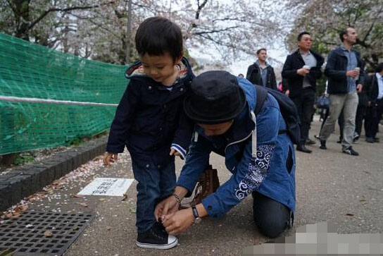 邓超为儿子系鞋带 网友称赞:中国好爸爸(图)