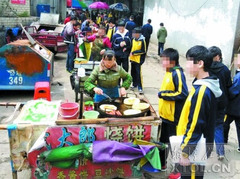     放学后，许多学生来到湘钢二中旁的“小吃一条街”买东西吃。（记者 陈旭东 摄）